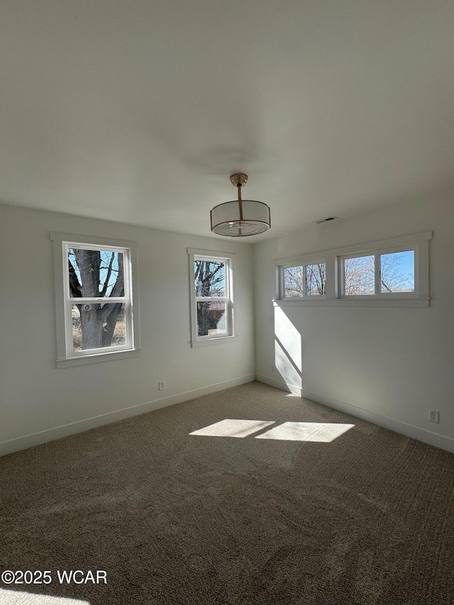 carpeted empty room with visible vents and baseboards