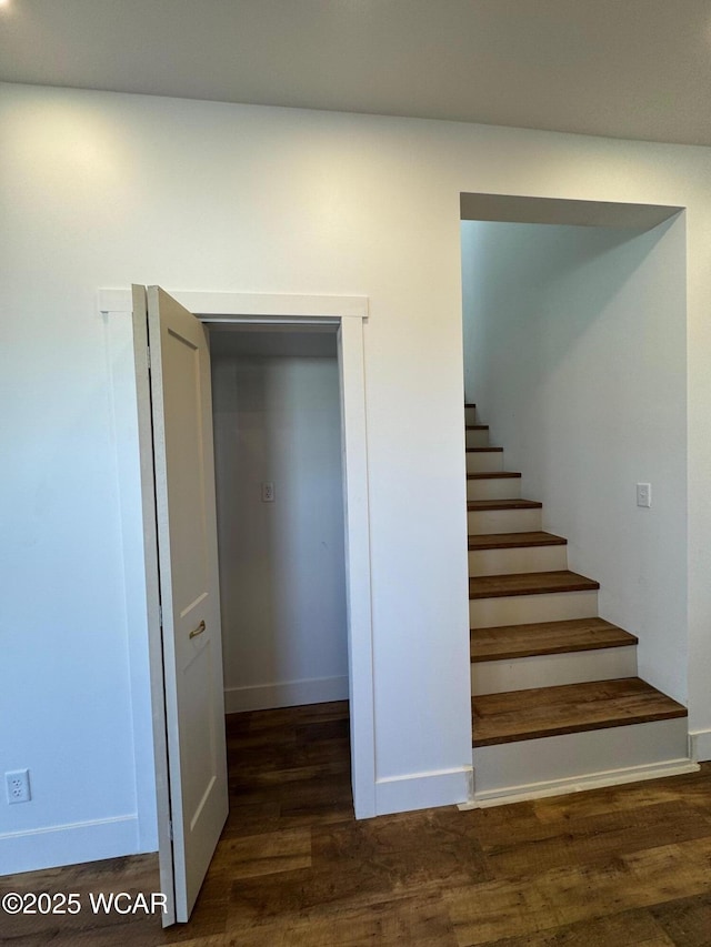 staircase featuring baseboards and wood finished floors