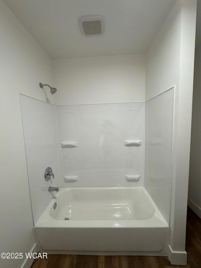 full bath featuring bathtub / shower combination and wood finished floors