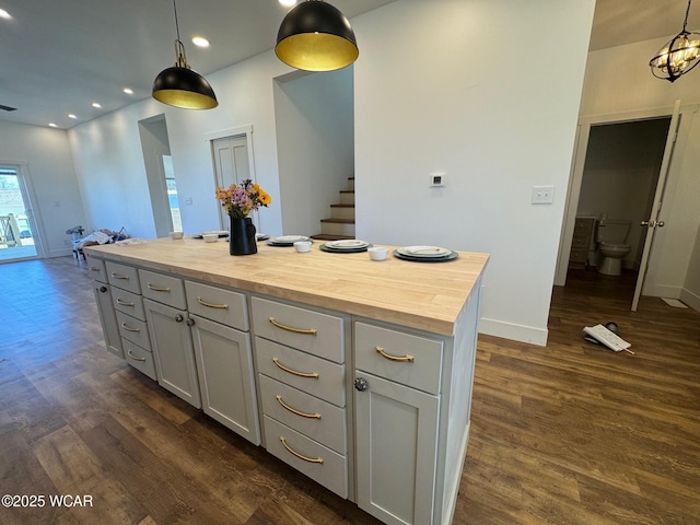 kitchen with dark wood-type flooring, baseboards, butcher block counters, recessed lighting, and hanging light fixtures