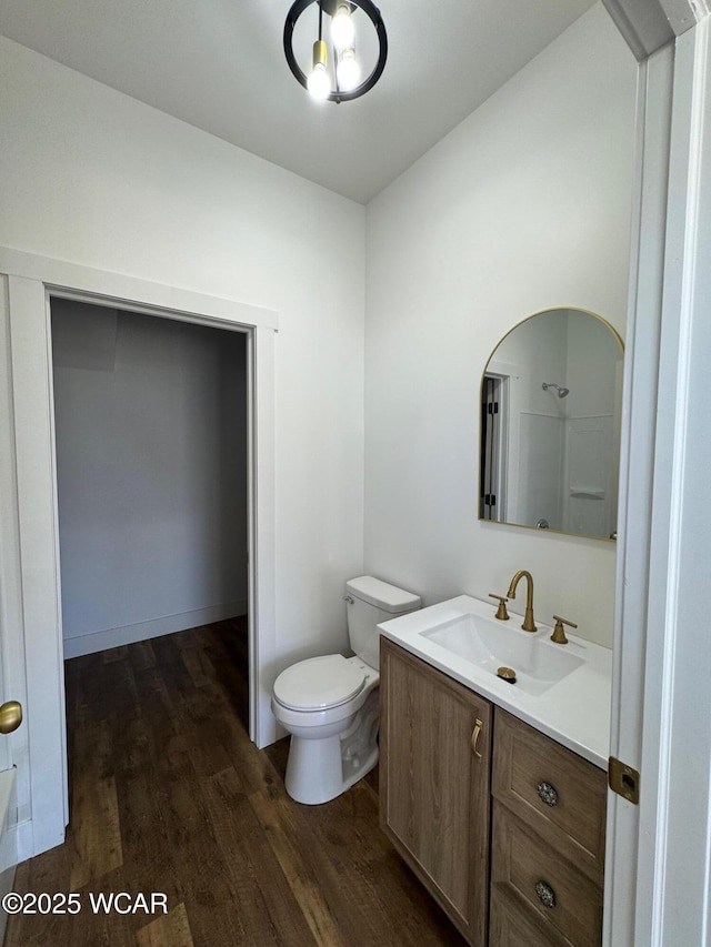 bathroom featuring toilet, wood finished floors, and vanity