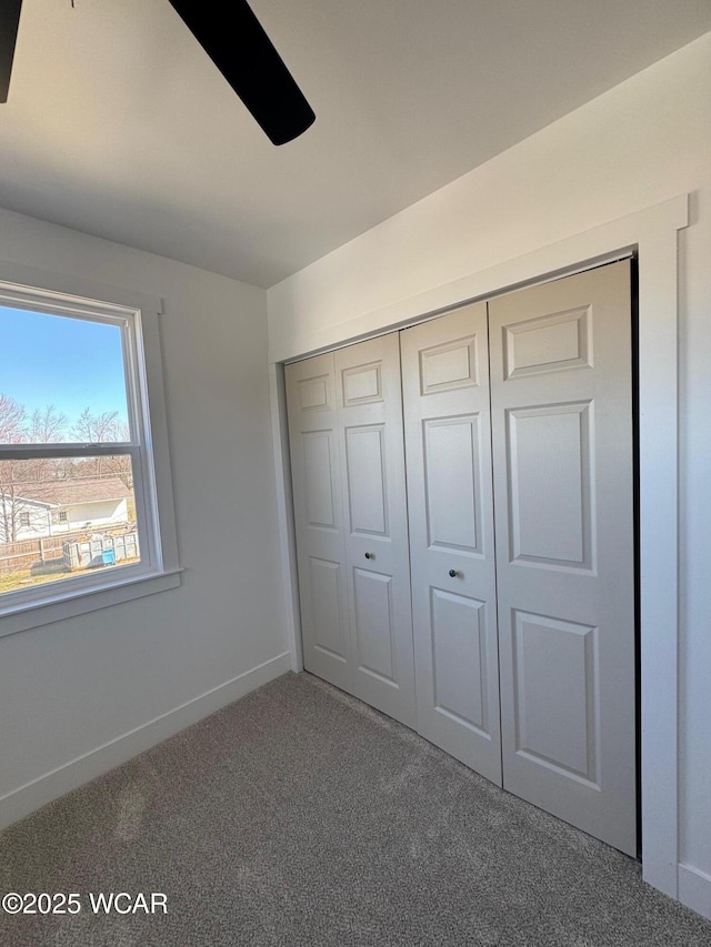 unfurnished bedroom featuring carpet flooring, baseboards, and a closet