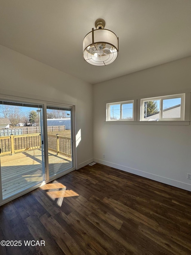 empty room with dark wood-type flooring and baseboards