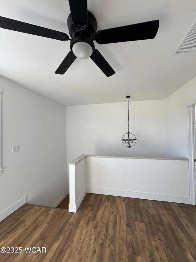 unfurnished room featuring visible vents, baseboards, and wood finished floors