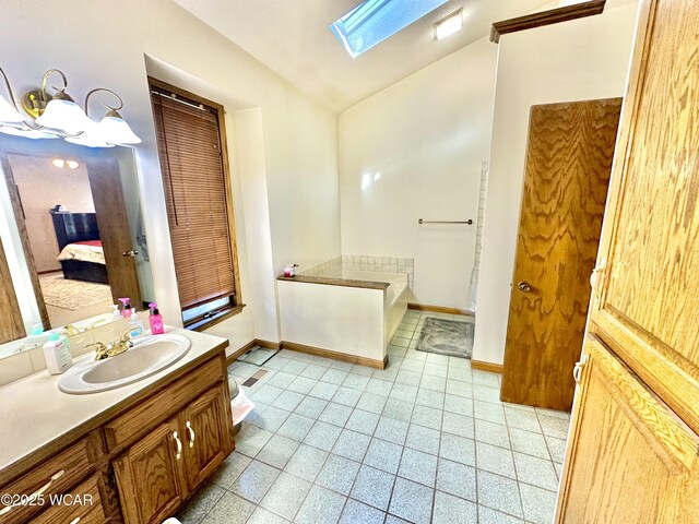 2969 Sands Rd, Lima, OH 45805 - bathroom featuring a skylight, lofted ceiling, ensuite bath, vanity, and baseboards