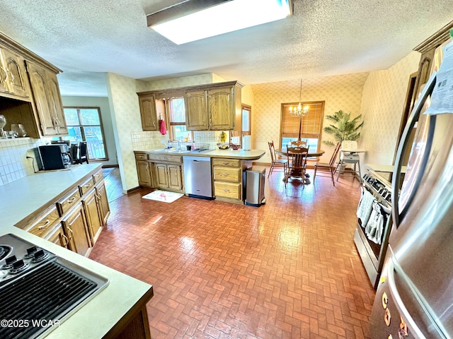 2969 Sands Rd, Lima, OH 45805 - kitchen featuring appliances with stainless steel finishes, wallpapered walls, light countertops, a chandelier, and a sink