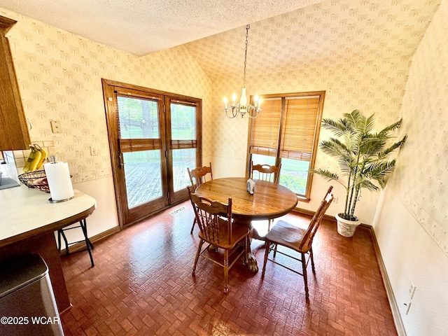 2969 Sands Rd, Lima, OH 45805 - dining room with wallpapered walls, a chandelier, vaulted ceiling, a textured ceiling, and brick patterned floors