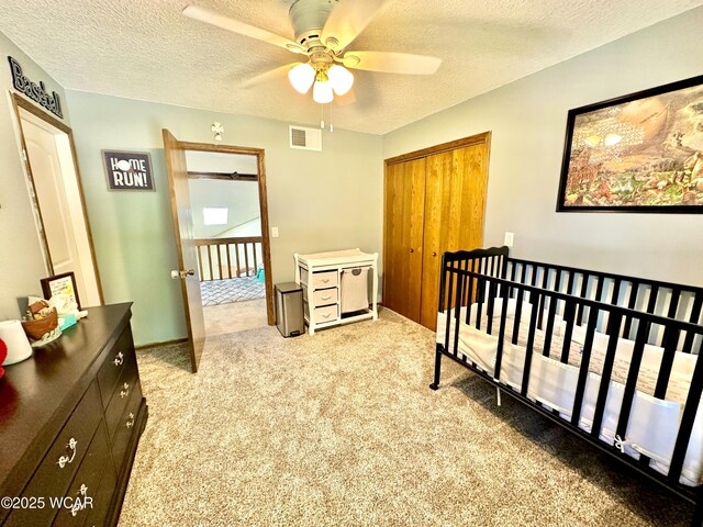 2969 Sands Rd, Lima, OH 45805 - carpeted bedroom with a closet, a textured ceiling, a crib, and a ceiling fan