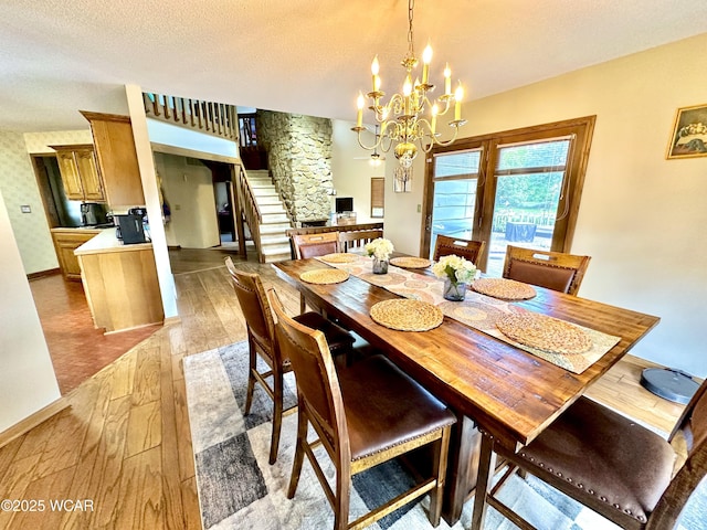 2969 Sands Rd, Lima, OH 45805 - dining space featuring light wood-type flooring, stairs, a chandelier, and a textured ceiling