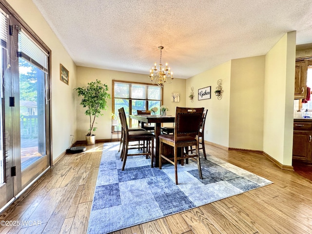 2969 Sands Rd, Lima, OH 45805 - dining room with a textured ceiling, light wood-type flooring, a chandelier, and baseboards