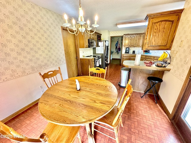 2969 Sands Rd, Lima, OH 45805 - dining space featuring brick patterned flooring, a chandelier, wallpapered walls, and baseboards