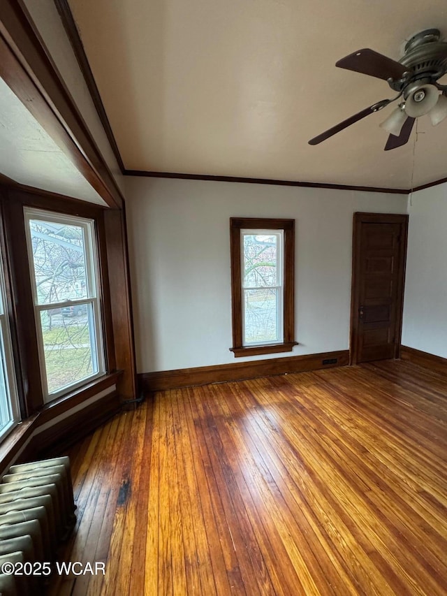 unfurnished room featuring crown molding, radiator, hardwood / wood-style floors, and ceiling fan