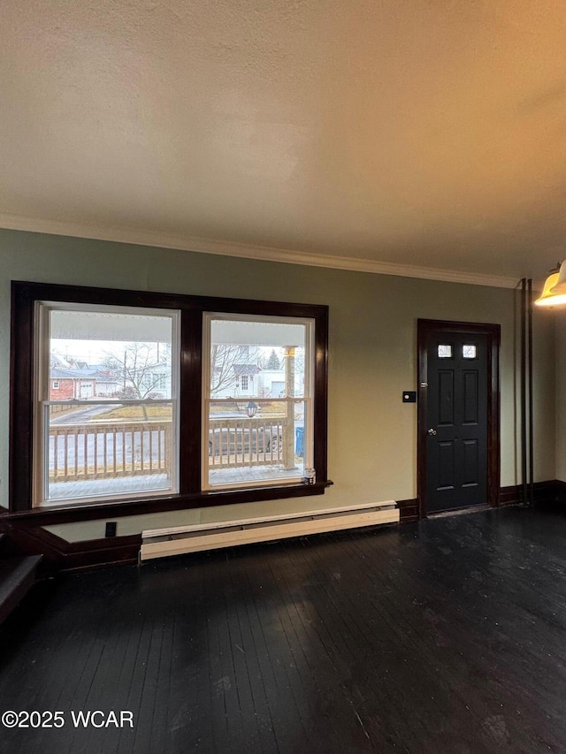 interior space featuring baseboard heating, plenty of natural light, crown molding, and hardwood / wood-style flooring