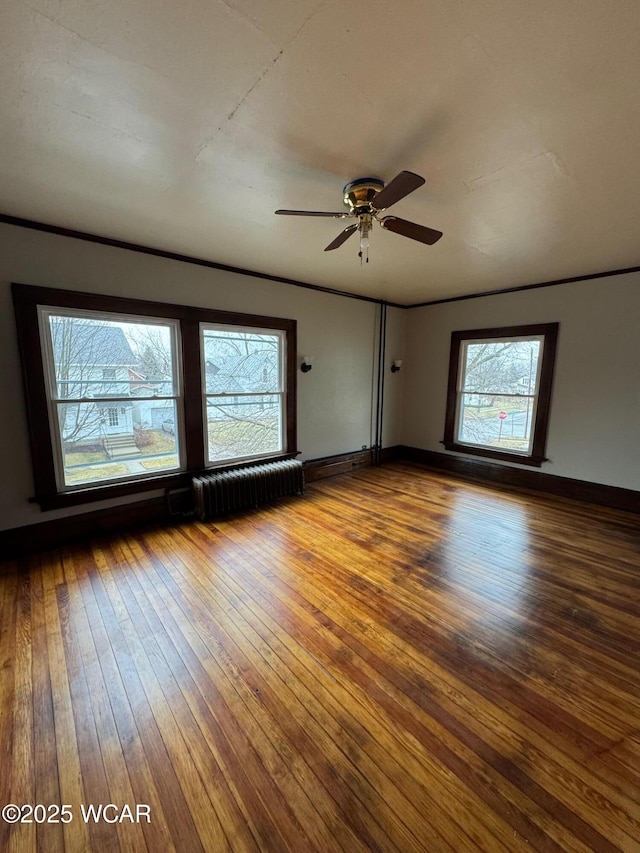 spare room with radiator, wood-type flooring, and ceiling fan