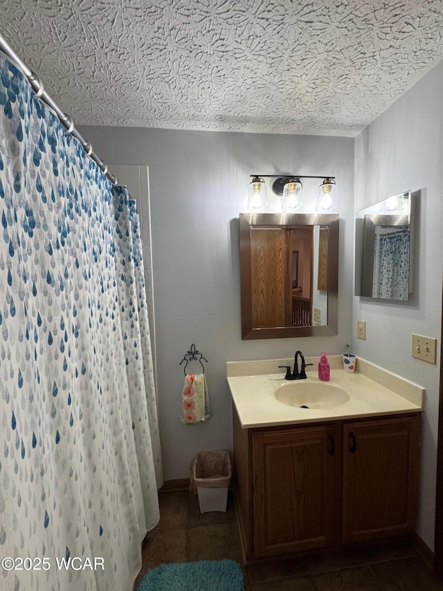 bathroom with a textured ceiling, vanity, a shower with shower curtain, and tile patterned flooring