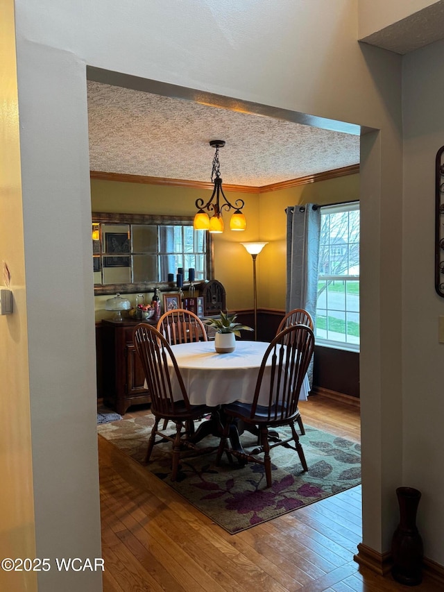 dining room with hardwood / wood-style floors, an inviting chandelier, and ornamental molding