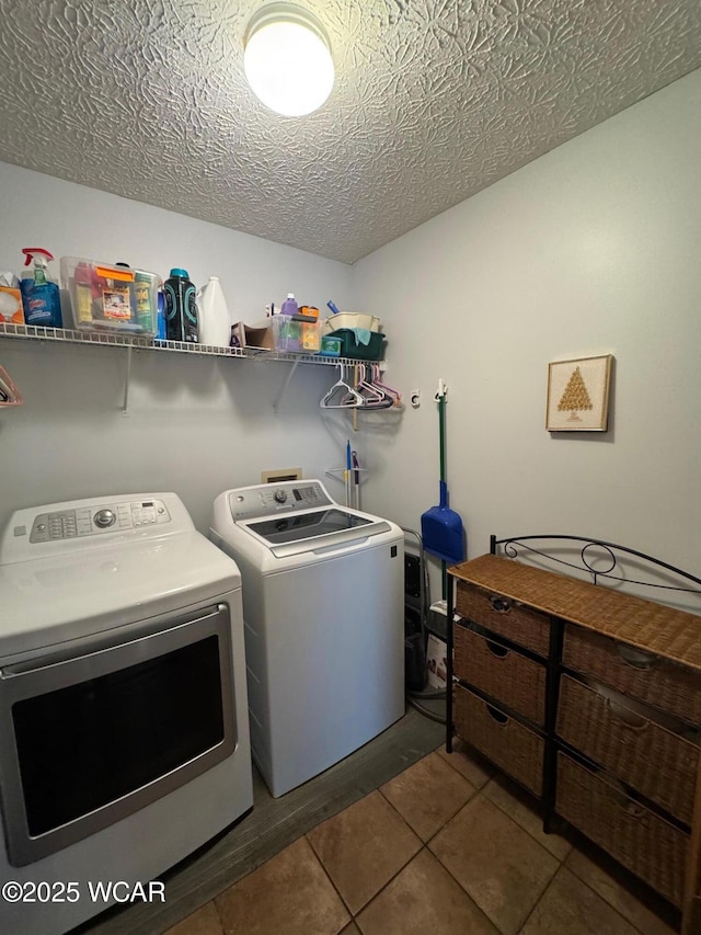 laundry area with washer and dryer, laundry area, tile patterned flooring, and a textured ceiling
