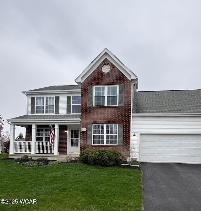 view of front of home featuring aphalt driveway, brick siding, a front lawn, and covered porch