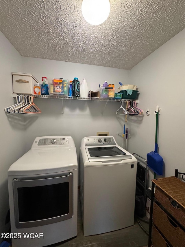 clothes washing area featuring independent washer and dryer, wood finished floors, laundry area, and a textured ceiling