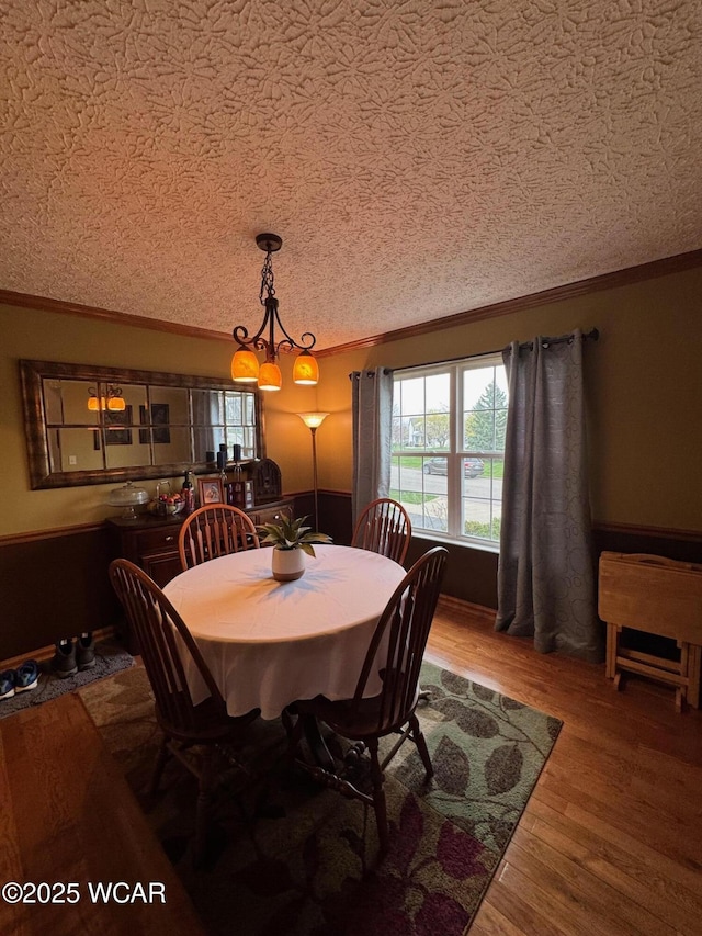 dining room featuring ornamental molding, an inviting chandelier, and wood finished floors