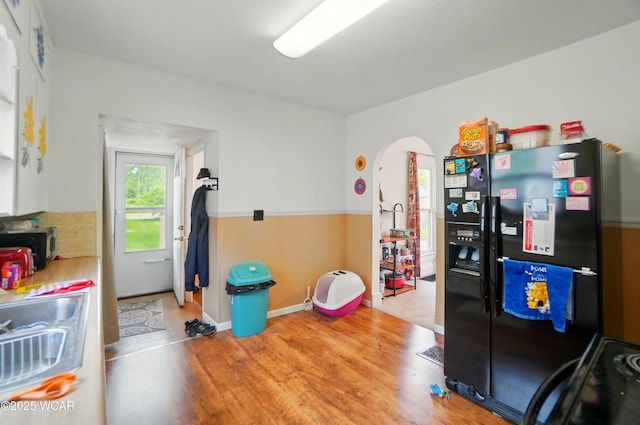 219 W O Connor Ave, Lima, OH 45801 - kitchen featuring black refrigerator with ice dispenser, wood finished floors, arched walkways, and a sink