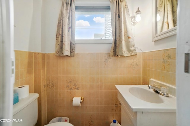 219 W O Connor Ave, Lima, OH 45801 - bathroom featuring tile walls, toilet, vanity, and a wainscoted wall