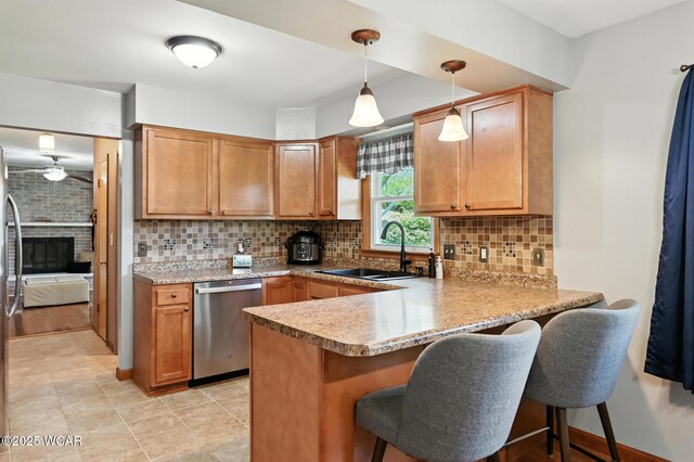 1851 Wendell Ave, Lima, OH 45805 - kitchen with appliances with stainless steel finishes, a peninsula, a breakfast bar area, light countertops, and backsplash