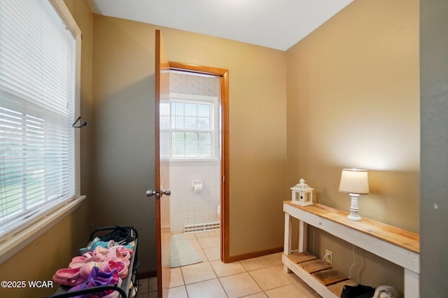 laundry room featuring light tile patterned flooring and tile walls