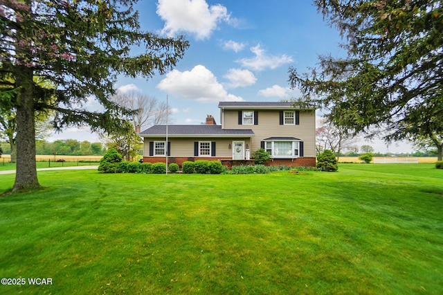 traditional home featuring a front yard and a chimney