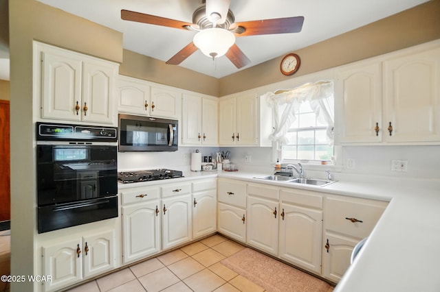 kitchen featuring black appliances, a warming drawer, a sink, ceiling fan, and light tile patterned floors
