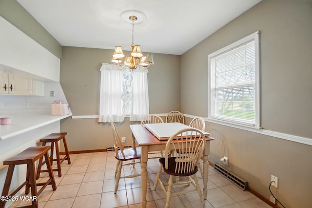 dining space with a chandelier, light tile patterned flooring, and baseboards
