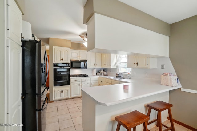 kitchen with oven, stainless steel fridge with ice dispenser, a peninsula, gas stovetop, and a kitchen bar