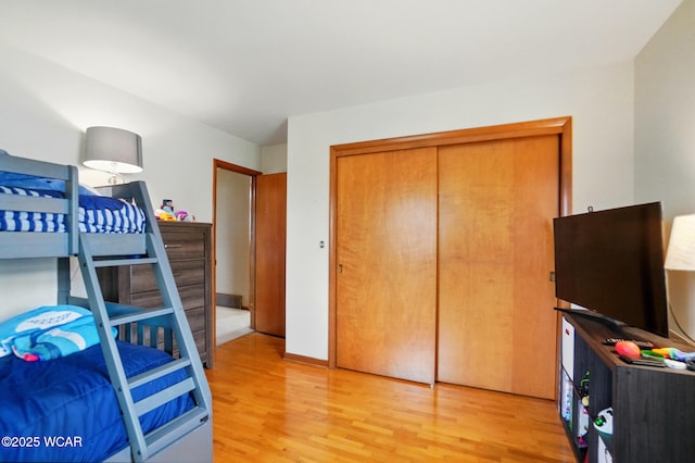 bedroom featuring light wood finished floors and a closet
