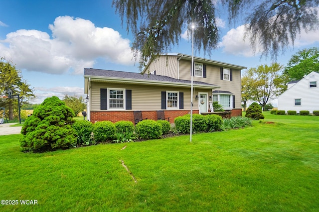 view of front of house with a front yard and brick siding