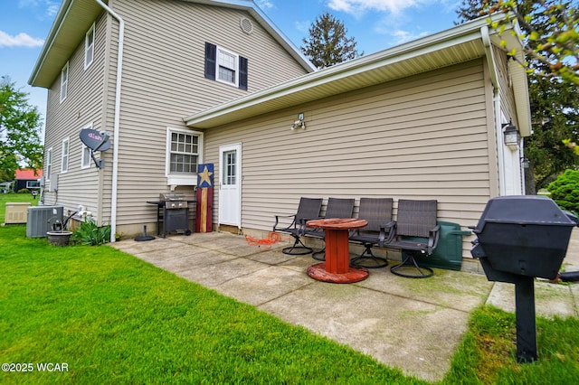 back of property featuring a lawn, a patio, and cooling unit