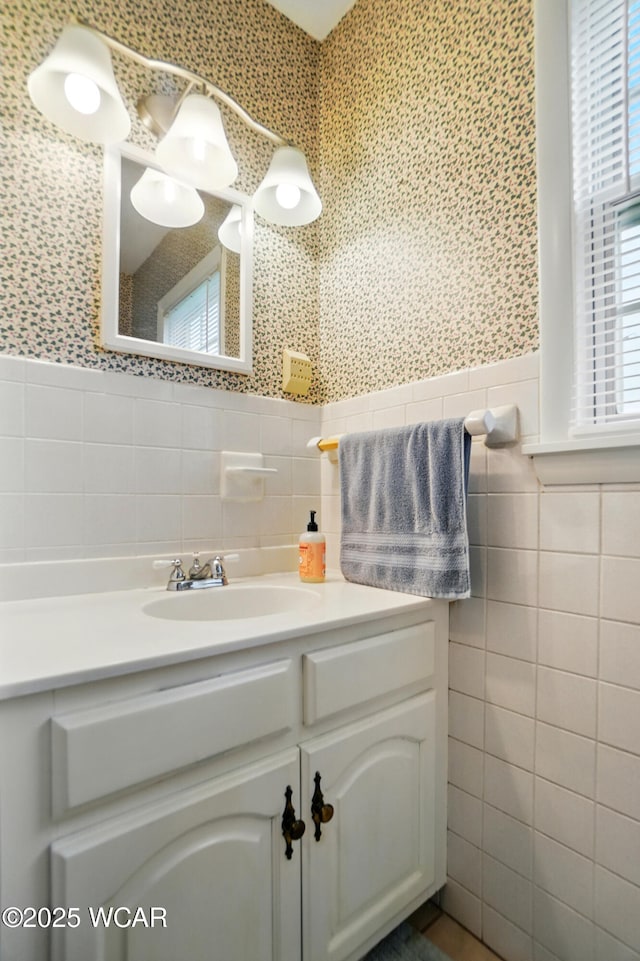 bathroom featuring tile walls, vanity, and a wainscoted wall