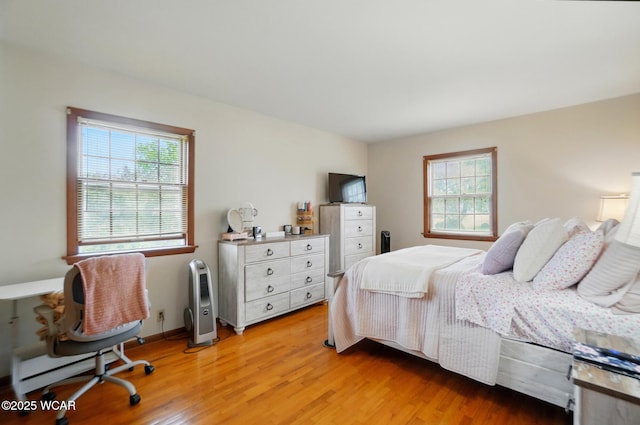 bedroom featuring multiple windows and light wood-style floors