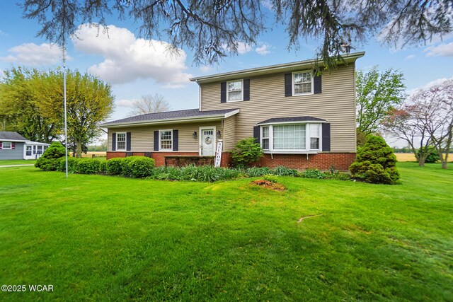 traditional-style home with a front yard and brick siding