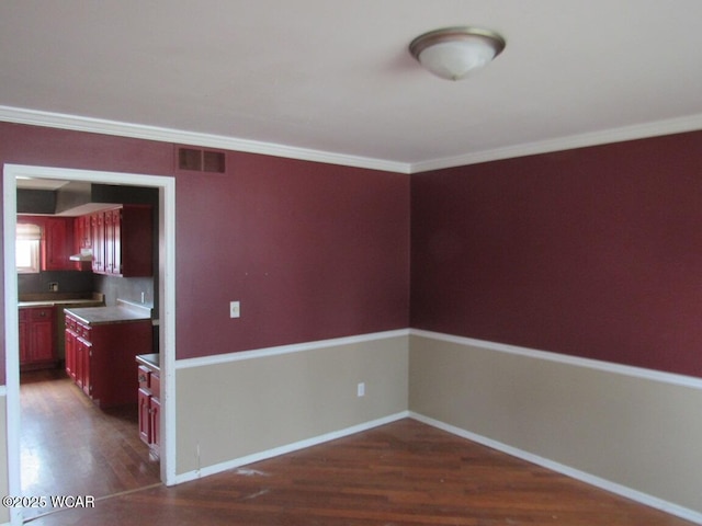 kitchen featuring crown molding and dark hardwood / wood-style floors