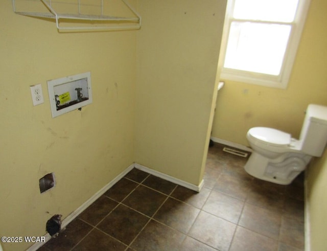 washroom with washer hookup and dark tile patterned flooring