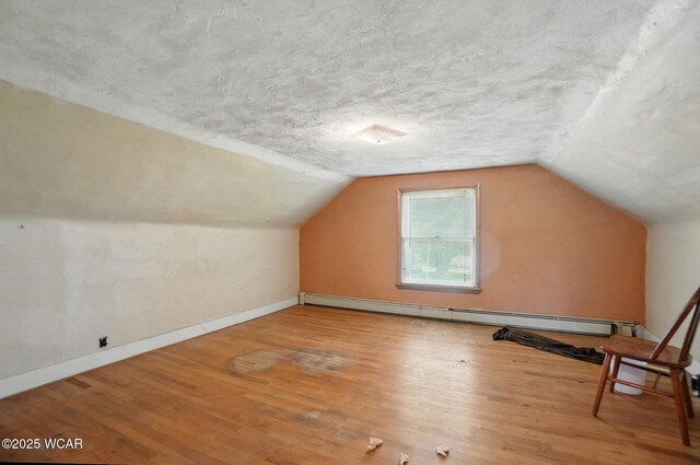 411 W Pattison Ave, Kenton, OH 43326 - bonus room featuring a baseboard heating unit, wood finished floors, vaulted ceiling, baseboards, and a textured ceiling