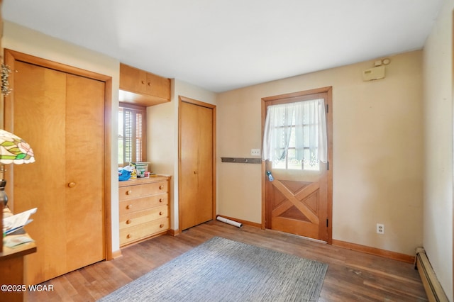 411 W Pattison Ave, Kenton, OH 43326 - doorway to outside with a baseboard heating unit, wood finished floors, plenty of natural light, and baseboards