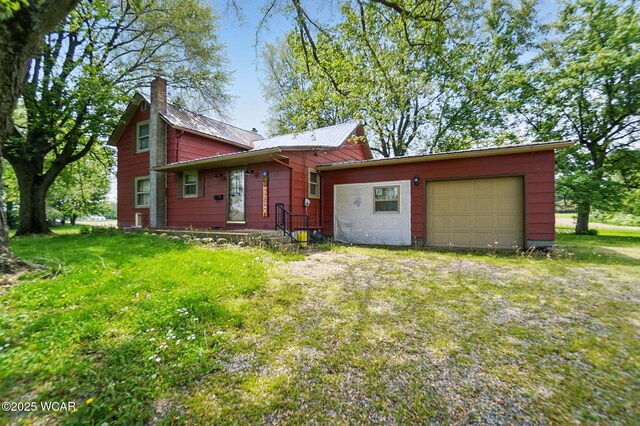 411 W Pattison Ave, Kenton, OH 43326 - view of front facade with a garage, a chimney, a front yard, and metal roof
