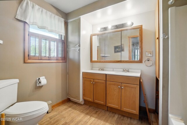 411 W Pattison Ave, Kenton, OH 43326 - full bath featuring wood finished floors, toilet, baseboards, and double vanity