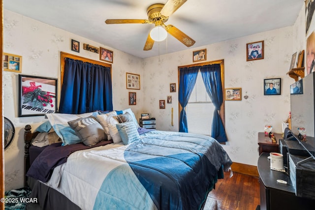 bedroom featuring wallpapered walls, a ceiling fan, and wood finished floors