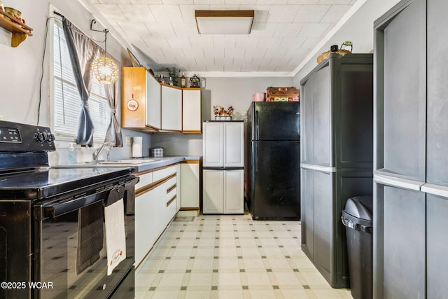 kitchen featuring light floors, a sink, white cabinets, light countertops, and black appliances