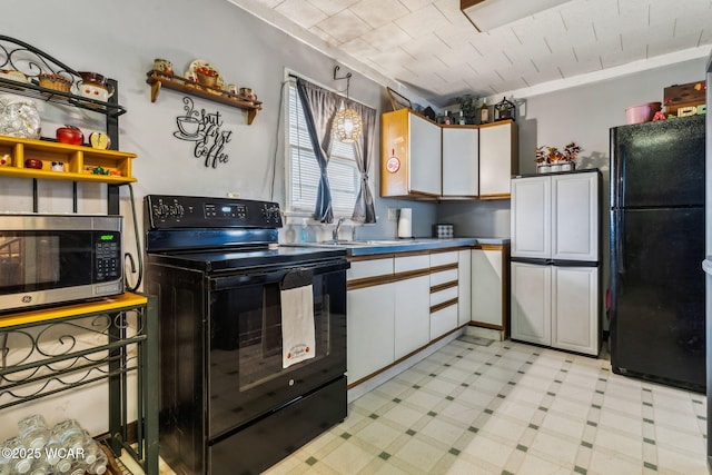 kitchen with light floors, black appliances, white cabinetry, open shelves, and a sink