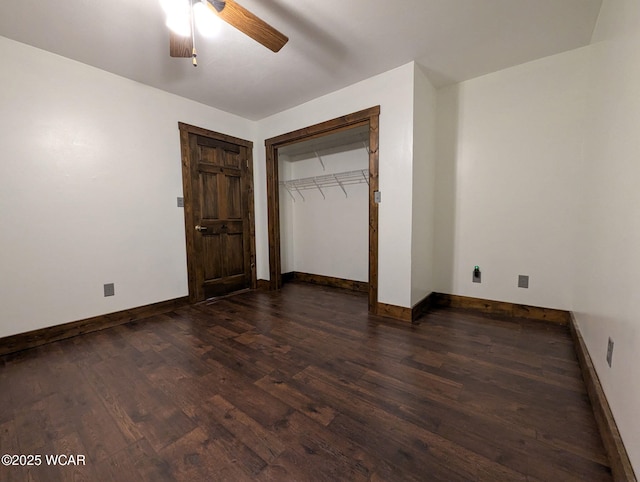 unfurnished bedroom featuring dark wood-type flooring, a closet, and baseboards