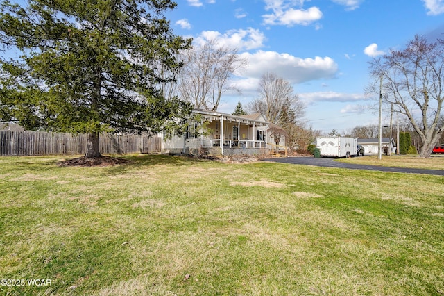 view of yard featuring a porch and fence