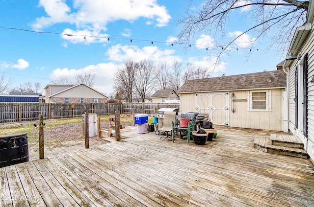 wooden deck with a fenced backyard, a shed, and an outbuilding